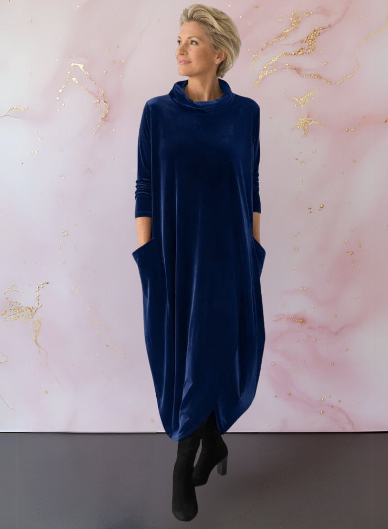 Side profile of a woman in the Leona velvet maxi dress, illustrating the flowing fit and integrated side pockets.
