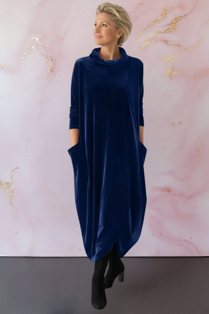 Side profile of a woman in the Leona velvet maxi dress, illustrating the flowing fit and integrated side pockets.