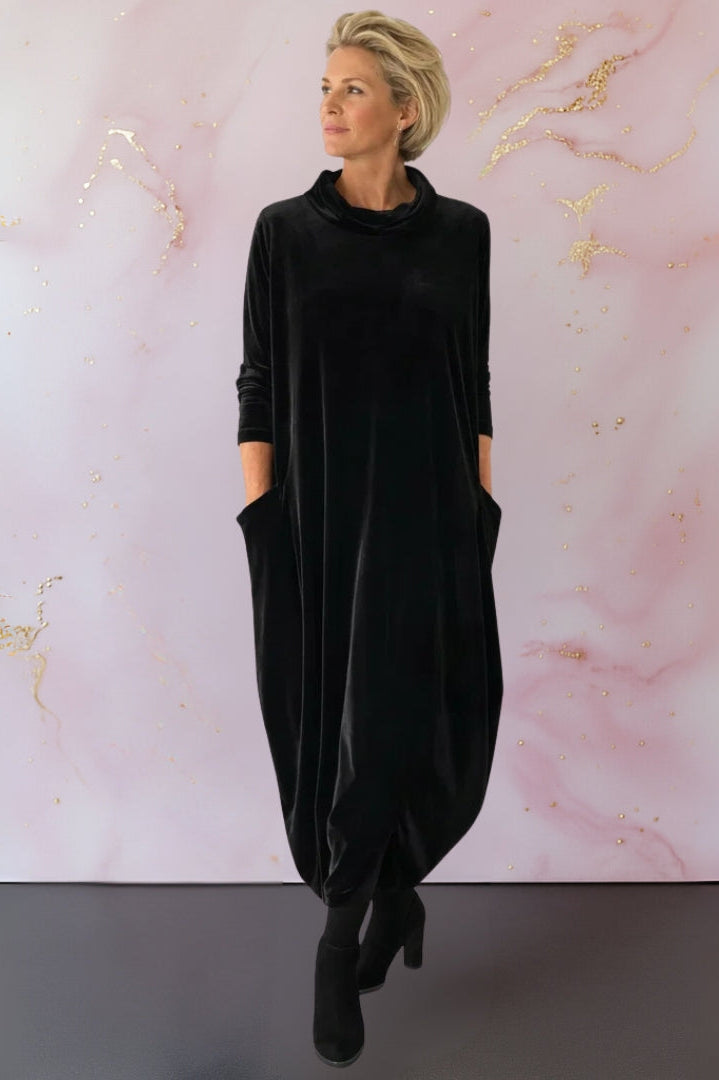 Full-length shot of the Leona velvet maxi dress in blue, styled with ankle boots for a chic daytime look.