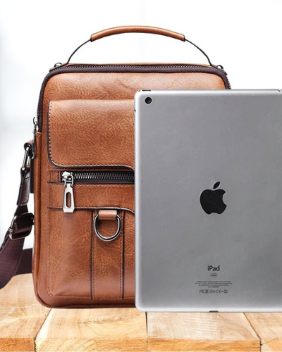 Overhead shot of the Caleb shoulder bag with daily items neatly arranged inside, showcasing its capacity.
