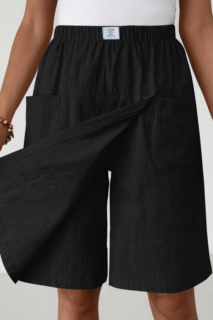 Close-up detail of the flattering wrap design and functional pockets on the dark blue skort shorts.