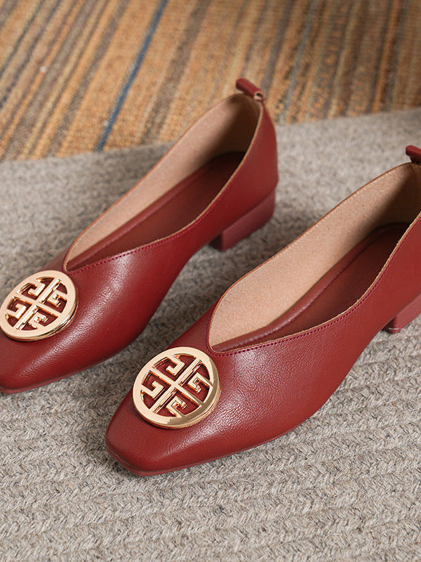 Close-up detail of the striking gold-tone circular accent on a beige square-toe flat, adding a touch of elegance.
