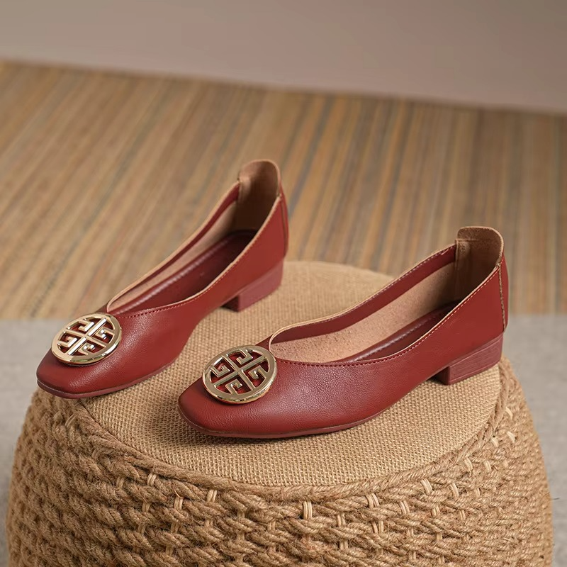 A person wearing stylish red square-toe flats, perfectly complementing tailored pants for a chic ensemble.