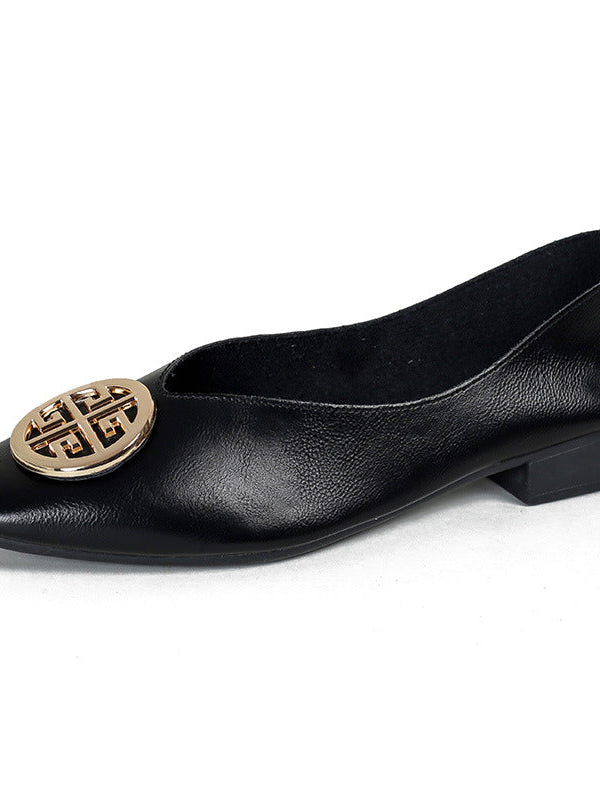 A pair of classic black square-toe flats displayed next to casual denim jeans, illustrating versatile styling.
