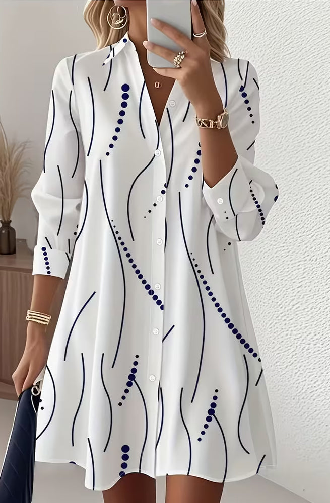 Front view of the Kira striped A-line dress in white, showcasing its wavy pattern and lapel collar.