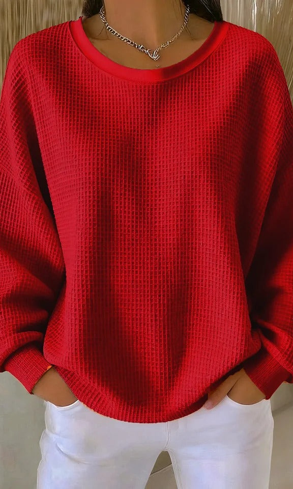 Side profile of a model wearing the Odette knit sweater in red, highlighting the relaxed drape.