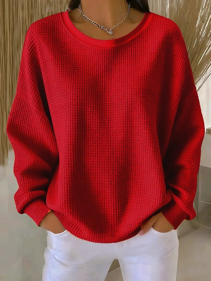 Side profile of a model wearing the Odette knit sweater in red, highlighting the relaxed drape.