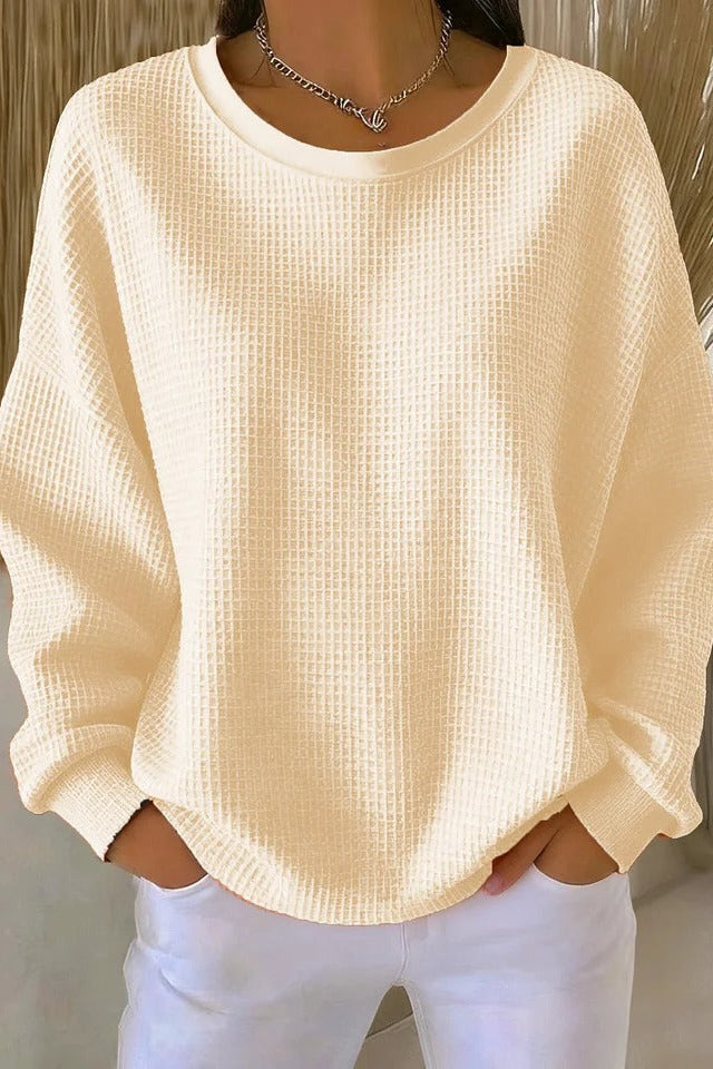 Model from behind in the Odette knit sweater in apricot, demonstrating its comfortable fit.