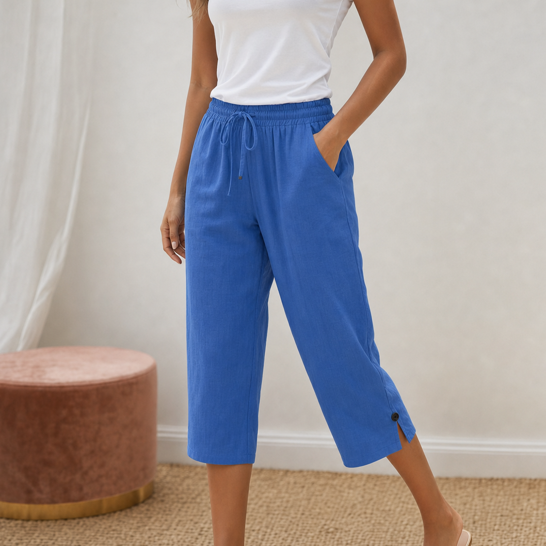 Woman walking on a beach, showcasing the airy feel of the capri-length cotton-linen trousers.