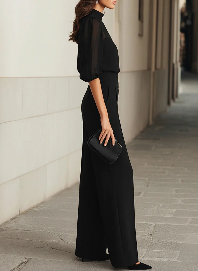 Side profile of a woman wearing the elegant Romy three-piece set, illustrating the flowing drape of the wide-leg trousers.