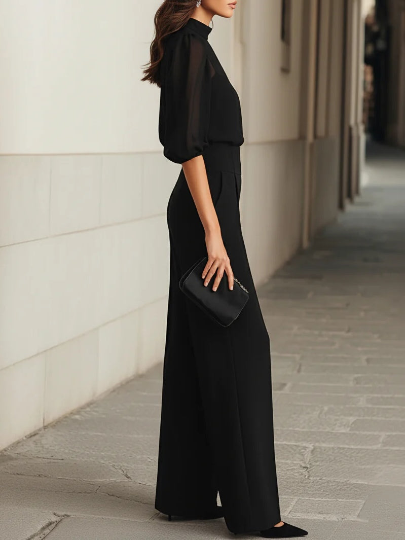 Side profile of a woman wearing the elegant Romy three-piece set, illustrating the flowing drape of the wide-leg trousers.