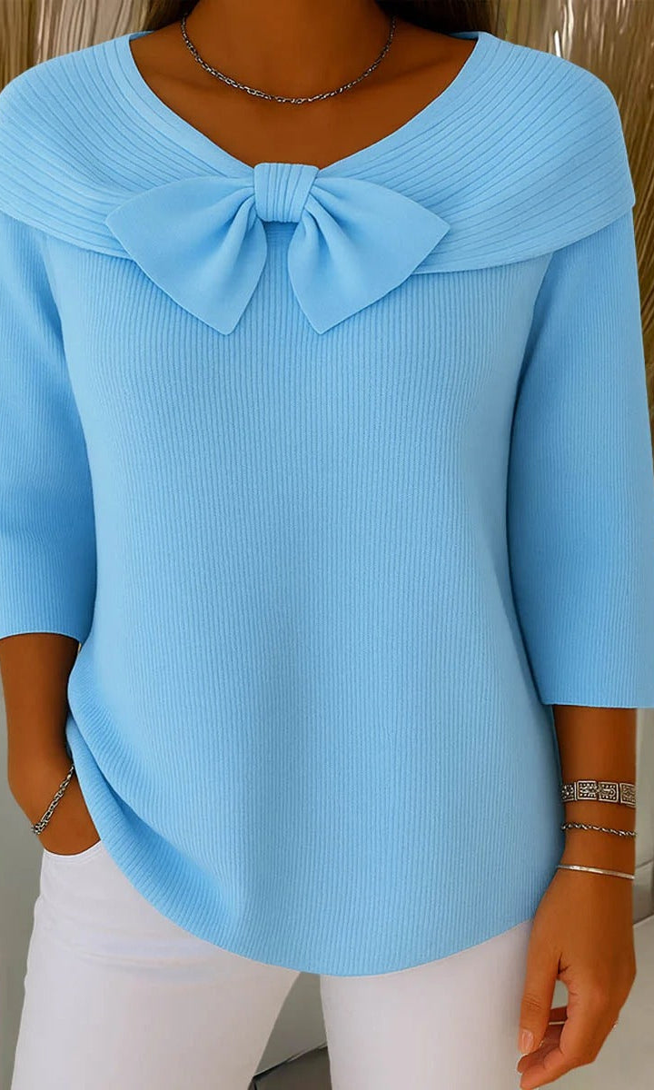 Front view of the Soraya relaxed knit tunic in a soft blue color, showcasing its loose fit and rounded neckline with decorative ties.