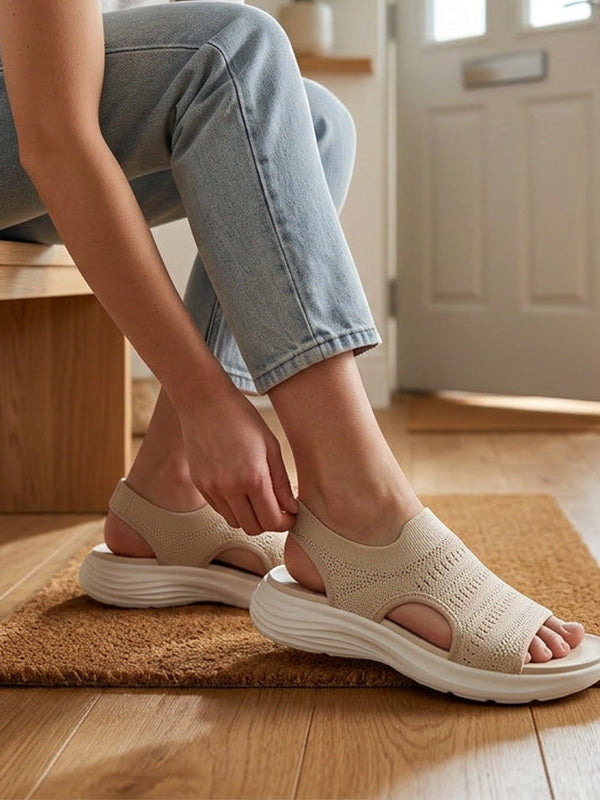 Woman's feet wearing beige platform sandals, showcasing how the knit upper gently adapts for comfort.