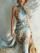 Side profile of a model wearing the Elysia animal print maxi dress, emphasizing the high side slit and defined waist.