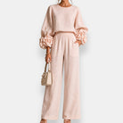 Close-up of the elasticated waist detail on brown flowing trousers, emphasizing comfort and pull-on style.