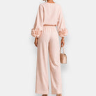 Side profile of a model wearing white wide-leg trousers, demonstrating their elegant movement and relaxed fit.