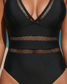 Model swimming gracefully in the black one-piece swimsuit, demonstrating freedom of movement.