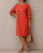 Woman seated comfortably in a broken white midi dress, perfect for a day out or vacation.