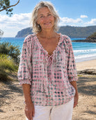 Side profile of the pink Xylia blouse, highlighting the flowing silhouette and three-quarter sleeves.