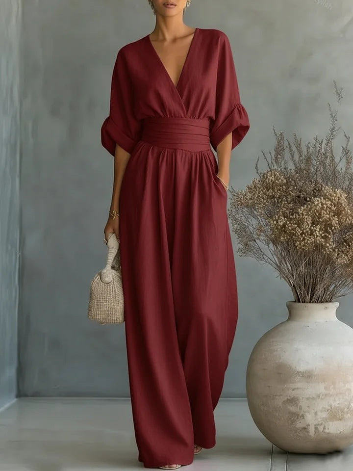 A burgundy jumpsuit worn by a seated model, highlighting the relaxed fit and all-day comfort.