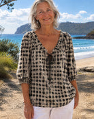 Detailed shot of the polka dot pattern on the black Xylia blouse, perfect for a chic look.