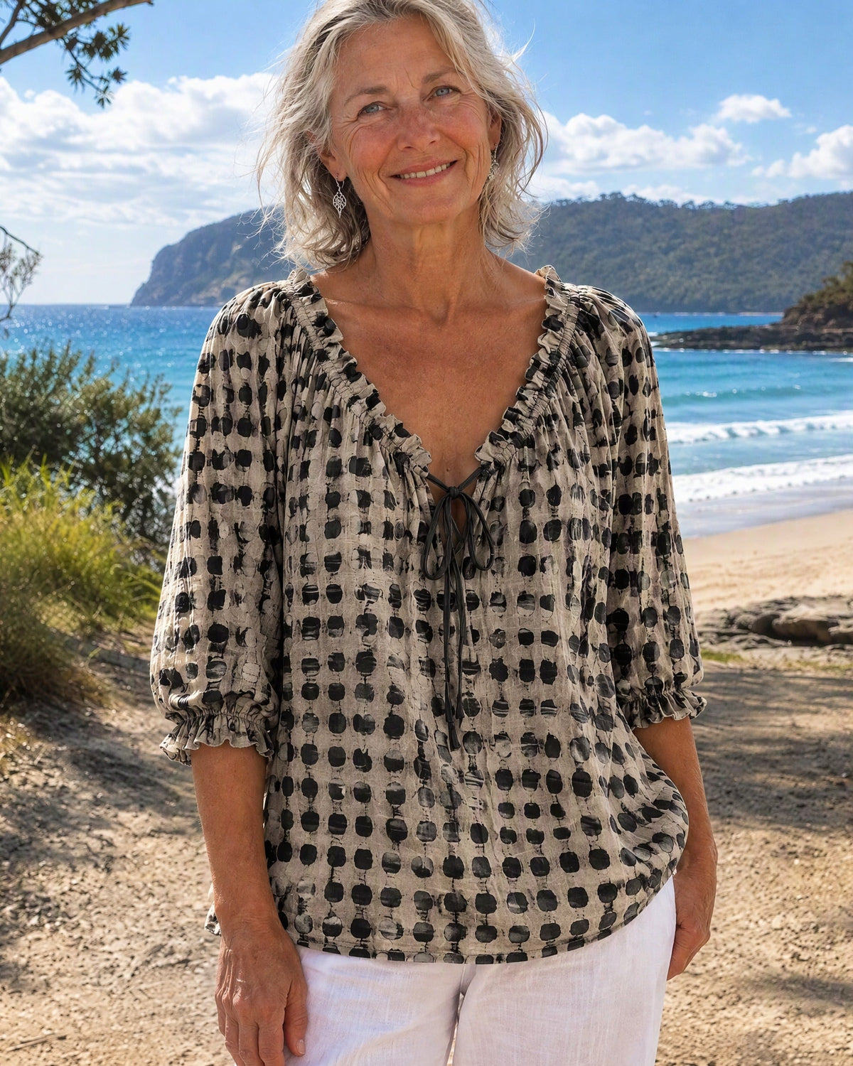 Detailed shot of the polka dot pattern on the black Xylia blouse, perfect for a chic look.