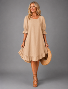 Full-length back view of a woman wearing a khaki Zenia dress, demonstrating its elegant versatility.