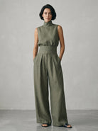 Stack of neatly folded wide-leg trousers in various appealing colors: beige, olive, light blue, and blush pink.