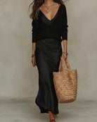 A folded white Romy ribbed knit pullover sweater, highlighting its compact and travel-friendly nature.