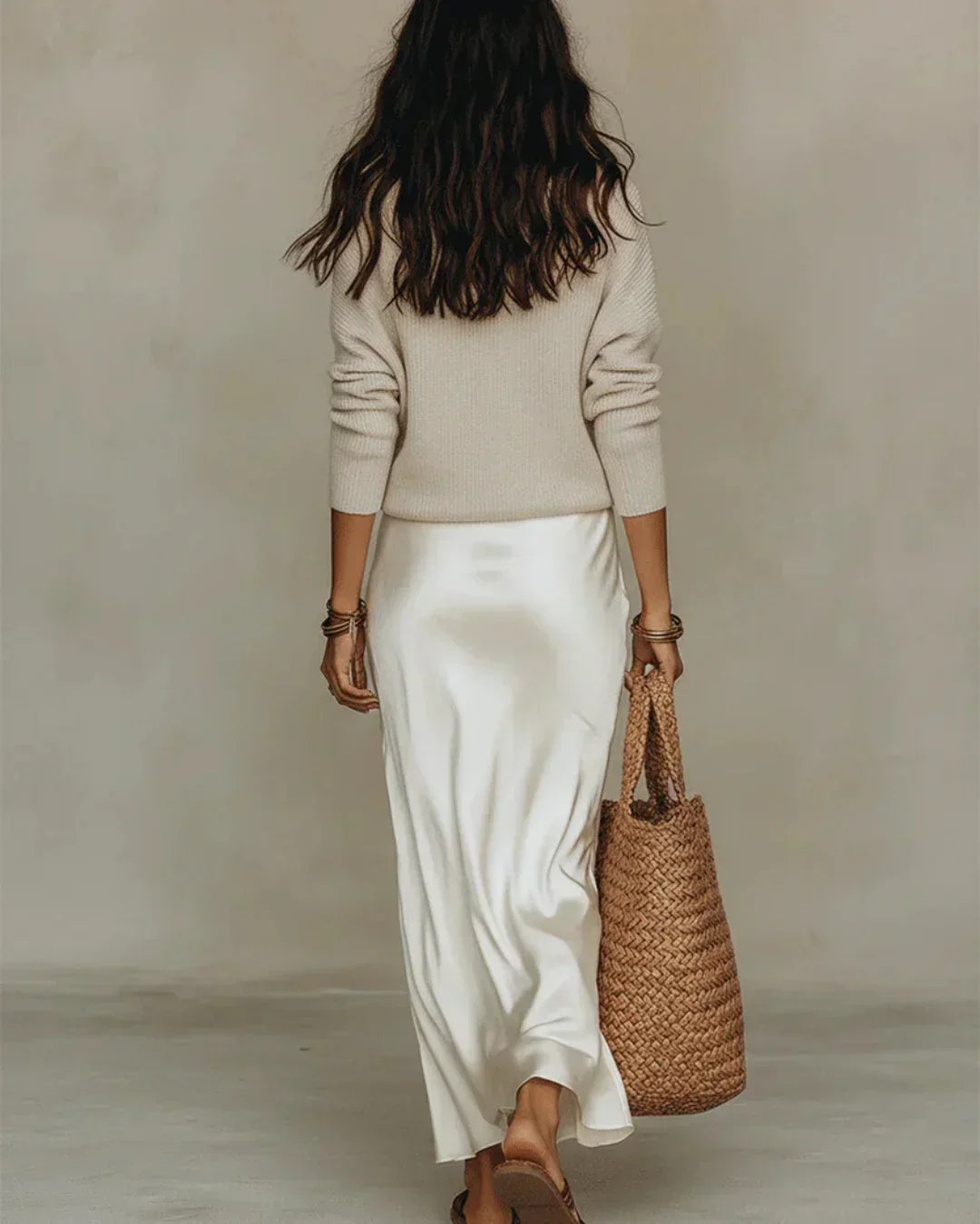 Back view of a black Romy ribbed knit pullover sweater, emphasizing its smooth, seamless design.