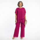 Model gracefully turning in a magenta blouse, showcasing the beautiful movement of its tiered design.