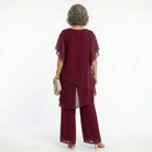 Back view of the blush pink tiered blouse, revealing its gentle lines and sophisticated, modest coverage.