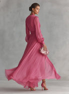 Front view of a pearlescent rose pink maxi dress with a deep V-neckline and long sleeves, perfect for formal events.