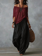 Lifestyle shot of the black casual trousers in a relaxed outdoor setting, paired with accessories.