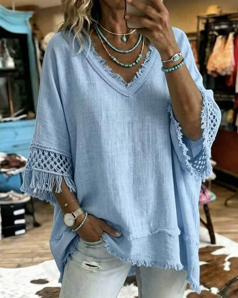 Close-up detail of the crochet-inspired trim on the sleeve of the blue bohemian blouse.