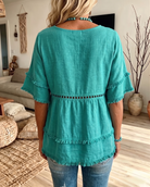 Close-up of the soft textured fabric of the blouse, highlighting its comfortable feel and subtle texture.