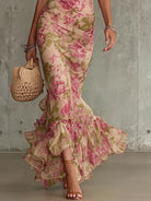 Side profile of a woman showcasing the flowing mermaid silhouette of the vintage floral maxi dress.