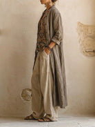 A pair of brown wide-leg trousers laid flat, displaying the texture and relaxed cut of the breathable fabric.