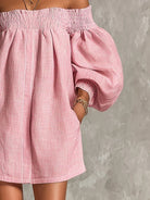 Detail shot of the gathered puff sleeve cuffs on the elegant off-shoulder mini dress in pink.