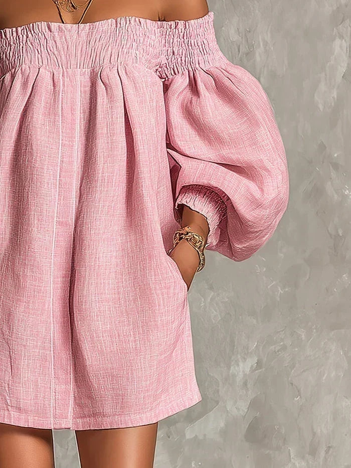 Detail shot of the gathered puff sleeve cuffs on the elegant off-shoulder mini dress in pink.