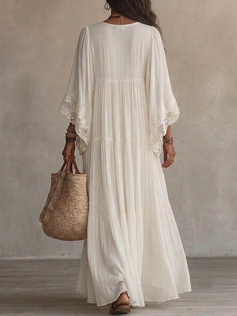 Close-up view of the delicate white lace V-neckline and wide bat sleeves on the maxi dress.