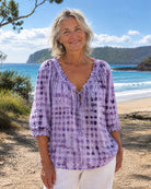 Model wearing the lilac Xylia blouse in a casual outdoor setting, demonstrating its comfortable style.