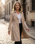 Lifestyle image of a woman walking confidently in the black Adeline trench coat, paired with smart casual attire.