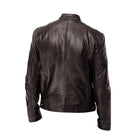 A grey Alden men's leather jacket draped over a chair, illustrating its relaxed yet refined presence.