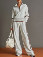 Woman wearing Anouk relaxed fit pants in a neutral tone, showcasing the comfortable wide-leg design in a dynamic pose.