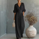 Rear view of the orange jumpsuit, emphasizing the seamless design and graceful fall of the fabric.