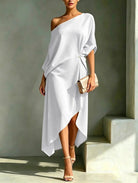 A model gracefully walking in a yellow Lana elegant asymmetrical midi dress, demonstrating its airy movement and dipped hem.