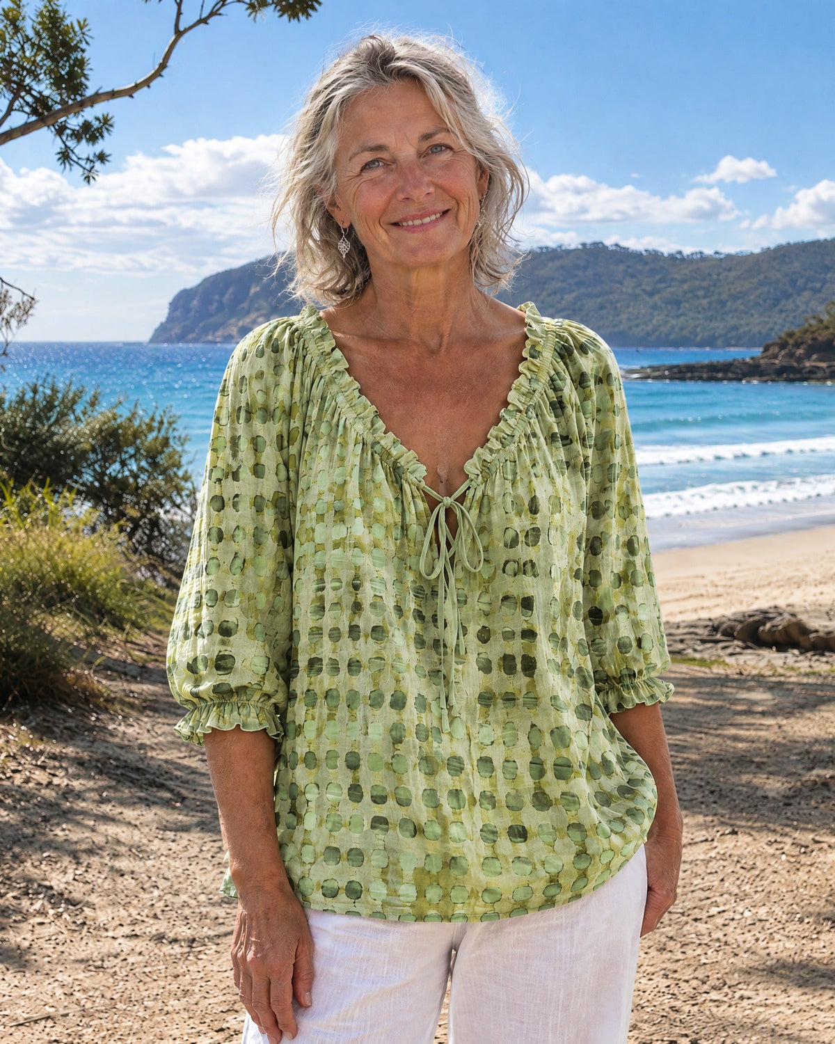Green Xylia blouse styled with light wash jeans, ideal for a relaxed summer ensemble.