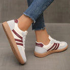 Side view of a wine red Elara orthopaedic cushioned trainer, presenting its rich color and ergonomic form.