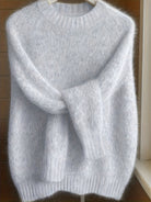 Side profile of a woman in the light grey Elara cashmere-blend sweater, highlighting the elegant silhouette and sleeve length.